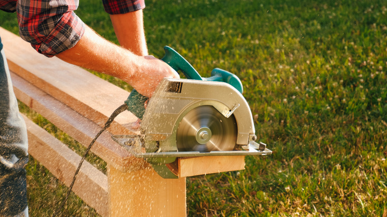 A man using a circular saw to cut lumber