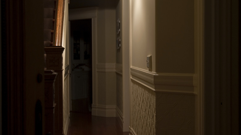A dark hallway with only a dim light to illuminate the space