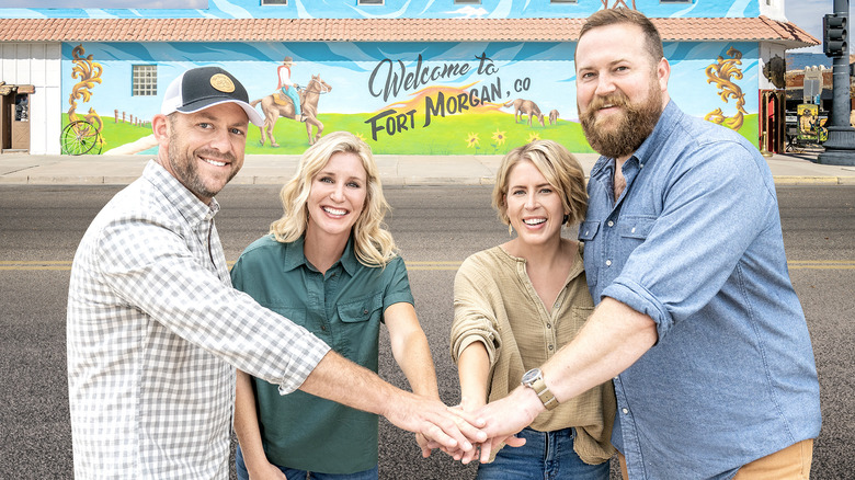 "Home Town Takeover" cast layering their hands on top of one another