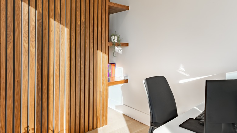 A home office with a wooden slat wall.