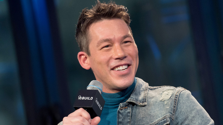 David Bromstad holding a mic and smiling.