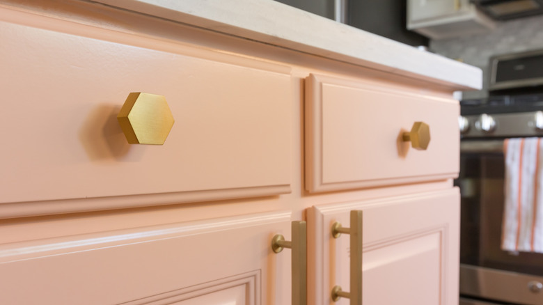 Pink kitchen cabinet with gold hardware