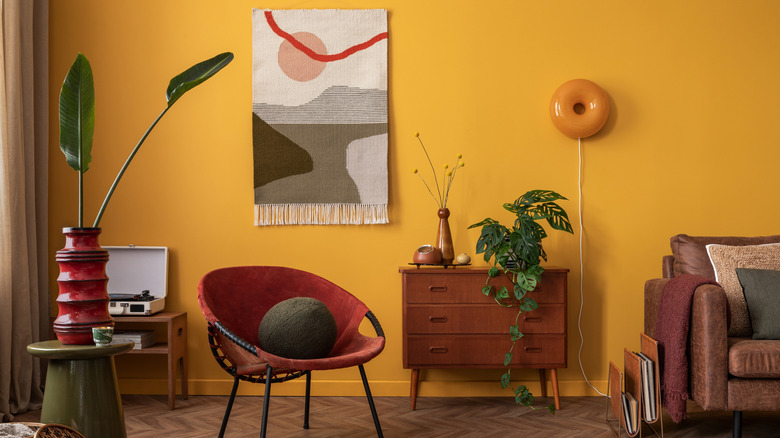 Living room decor with various warm shades like red, brown, and orange, as well as pops of green elements