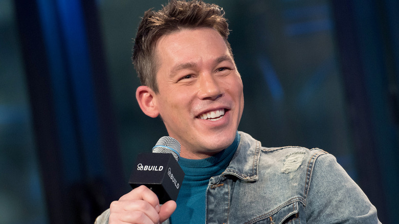 David Bromstad smiles while holding a microphone