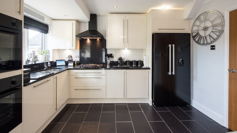 black and white kitchen with black tile flooring