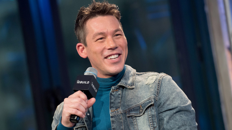 David Bromstad smiles while holding a microphone