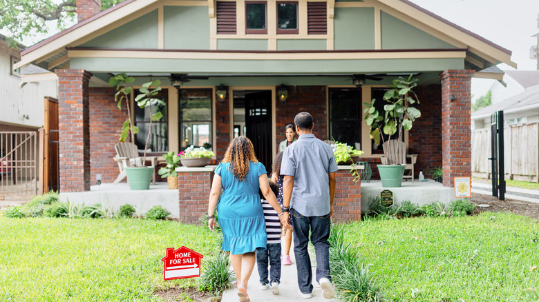Family of three entering a home for sale
