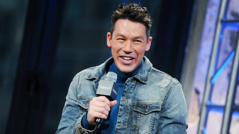 Designer/ TV personality David Bromstad smiling while holding a microphone