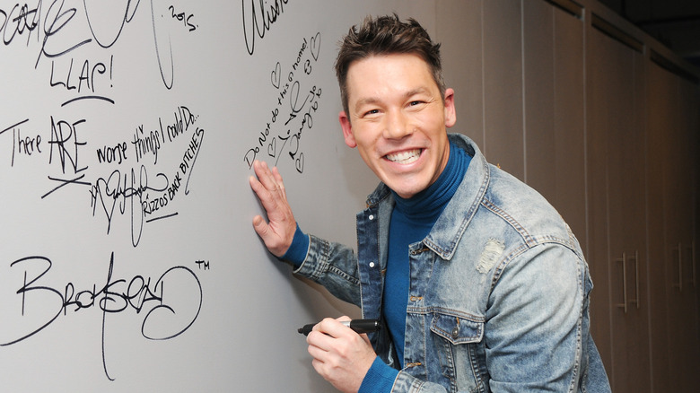 Designer David Bromstad signing a wall
