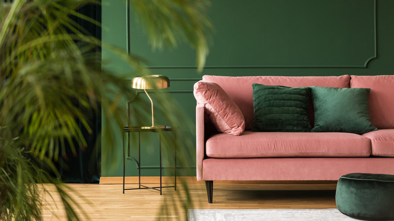 Living room with pink sofa and emerald green paint and accent colors