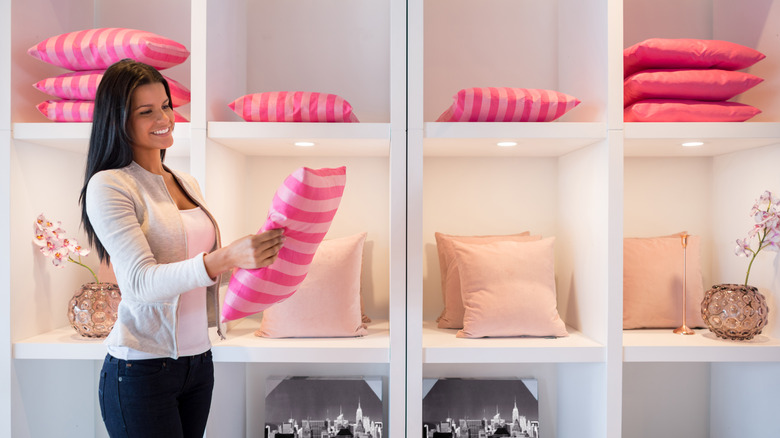woman looking at pink cushion