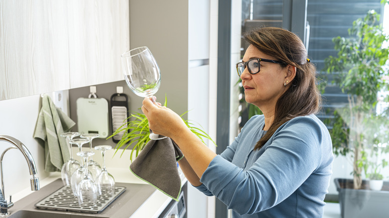 Woman examining a freshly washed wine glass