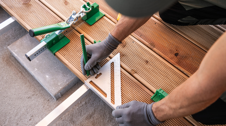 A carpenter is building a wooden deck