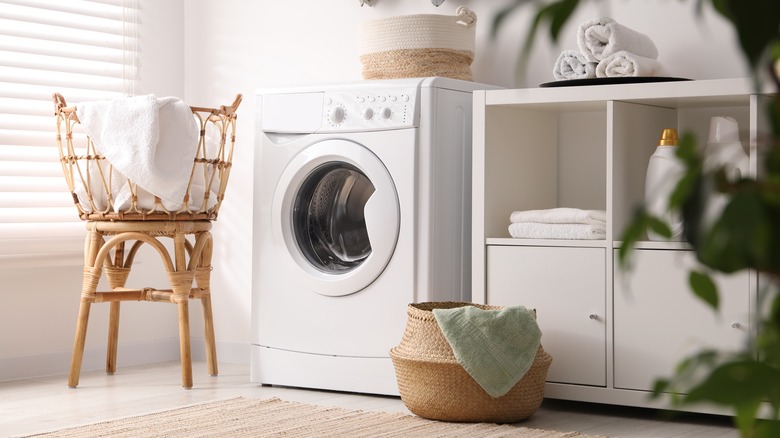 Laundry room with washing machine and cabinets
