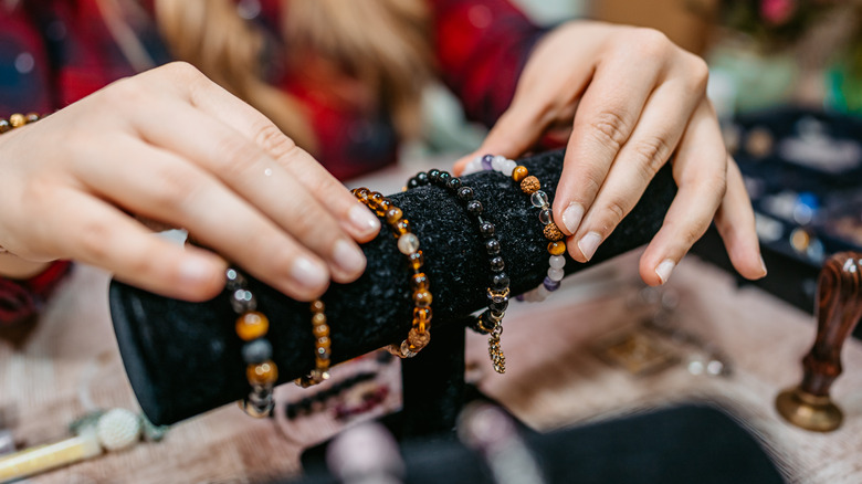 Woman arranging bracelets on a felt stand