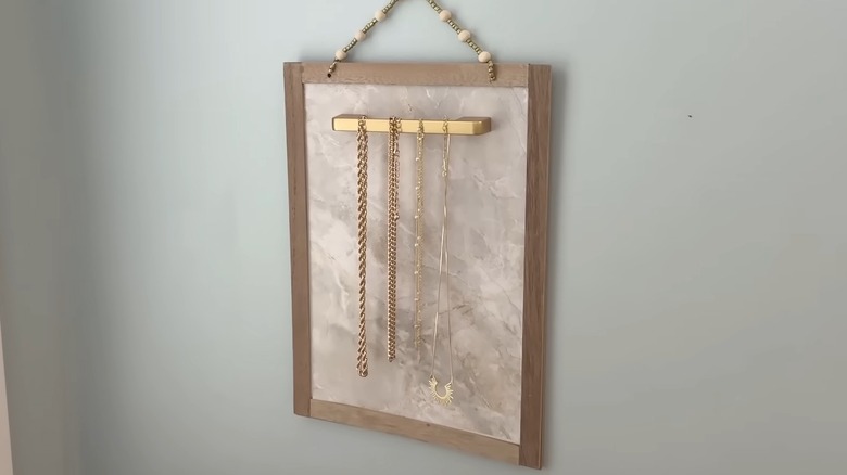 Gold-colored necklaces on a hanging jewelry organizer