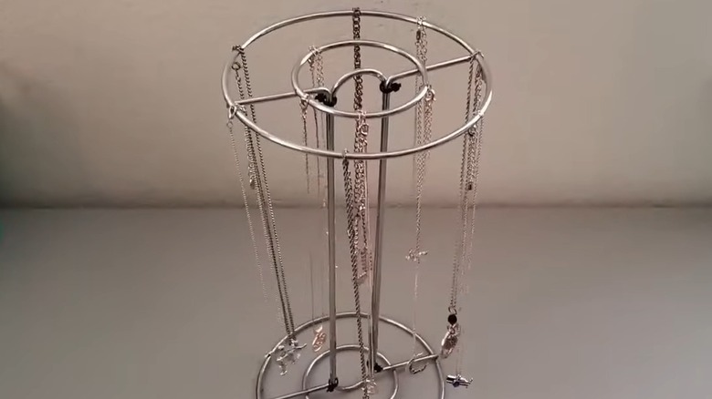 Two paper towel holders tied together for hanging necklaces