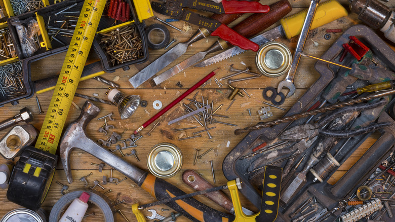 messy garage workbench covered in tools and hardware