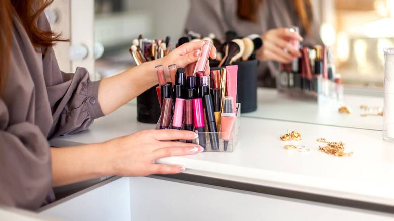 Woman going through lipstick tubes