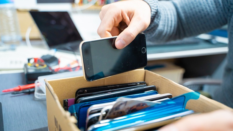 Person organizes old electronics in a box