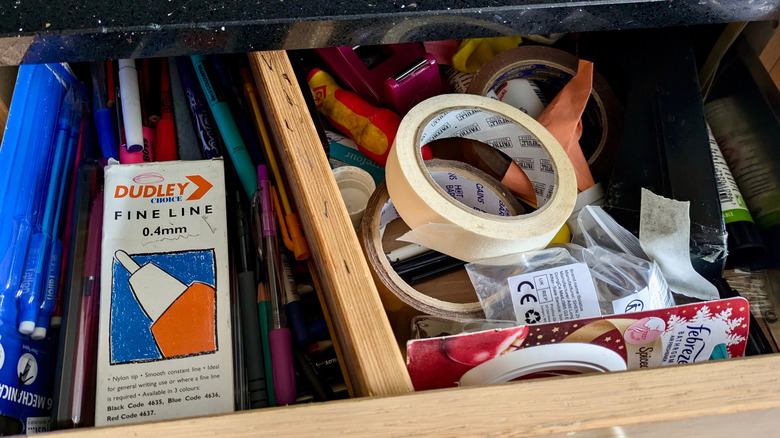 Messy drawer filled with miscellaneous household items