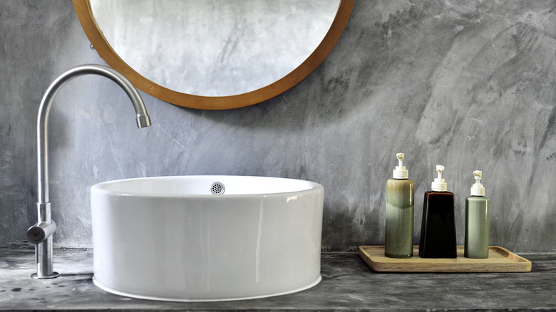 Neat and tidy bathroom counter with soap and lotion dispensers on a small wood tray