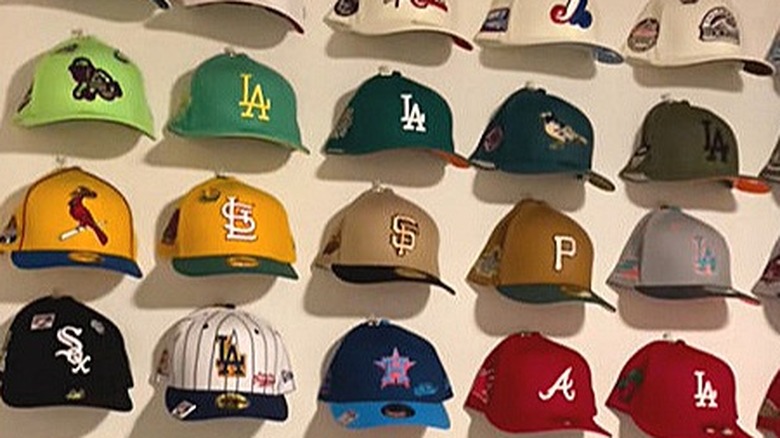 Baseball hats hanging on a wall using a binder clip and thumb tack
