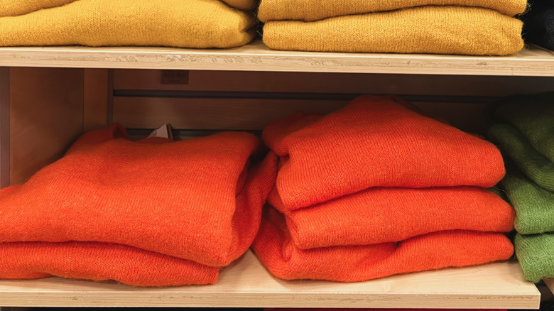 Rows of folded sweaters on shelves