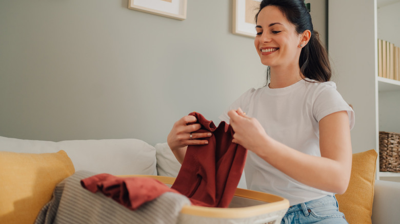 woman organizing clothes in a bin