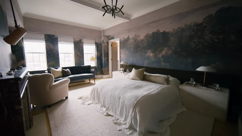 Nate Berkus' primary bedroom is enveloped in wallpaper depicting a forest scene