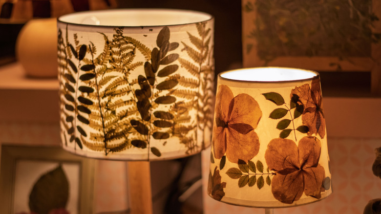 Lampshades with pressed flowers on the inside, creating a silhouette