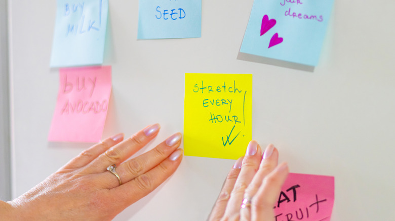 Woman hanging sticky note reminders