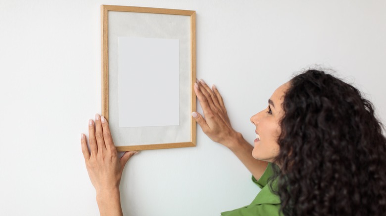 Woman hanging picture frame