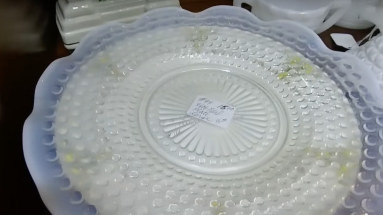 A platter in the pattern Moonstone by Hocking Glass Company sits on the shelf in a thrift store.