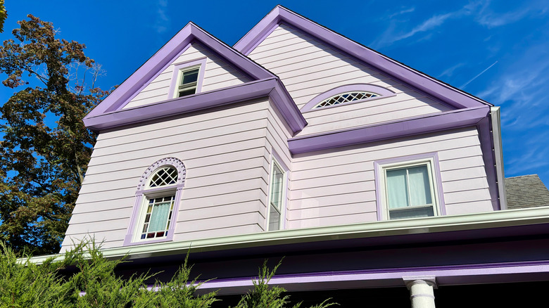 View of upper story of house painted lilac with purple trim