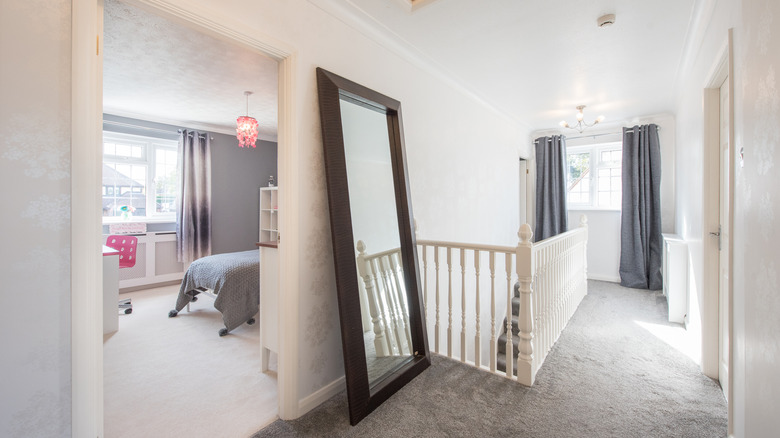 A giant leaning mirror on stair landing of house