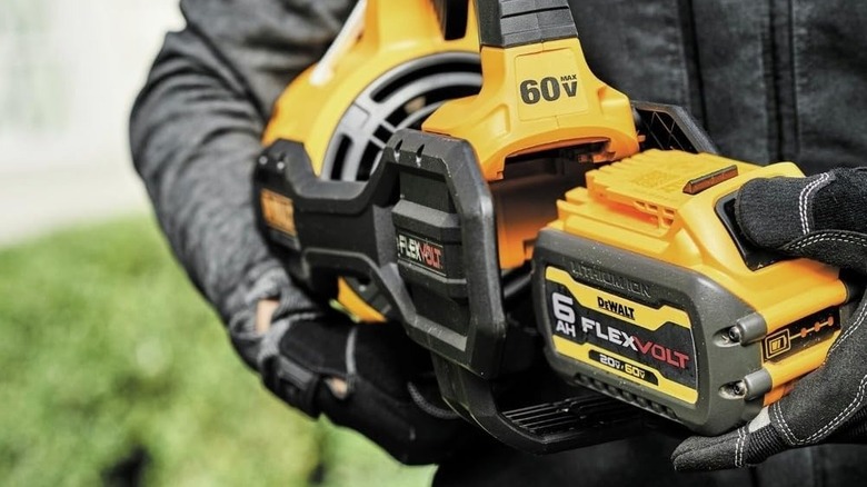 Person inserting a battery in a DeWalt leaf blower