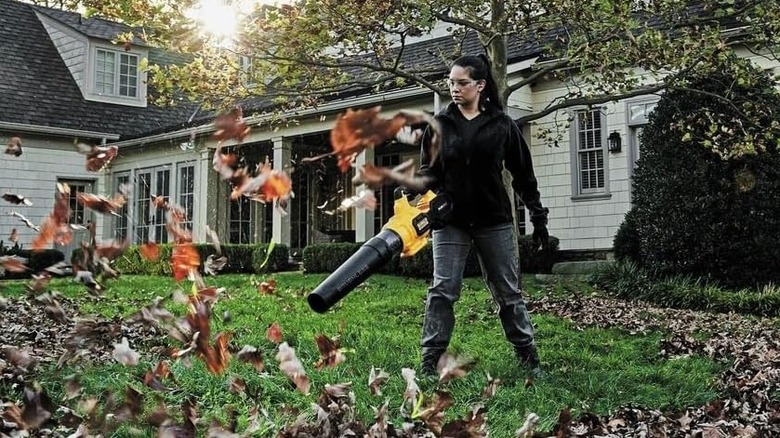 Woman using a DeWalt leaf blower on the lawn