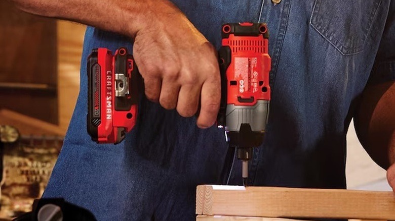 A person using a Craftsman impact driver