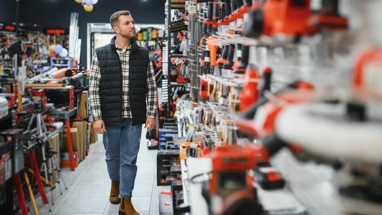 Man browsing power tools in a hardware store