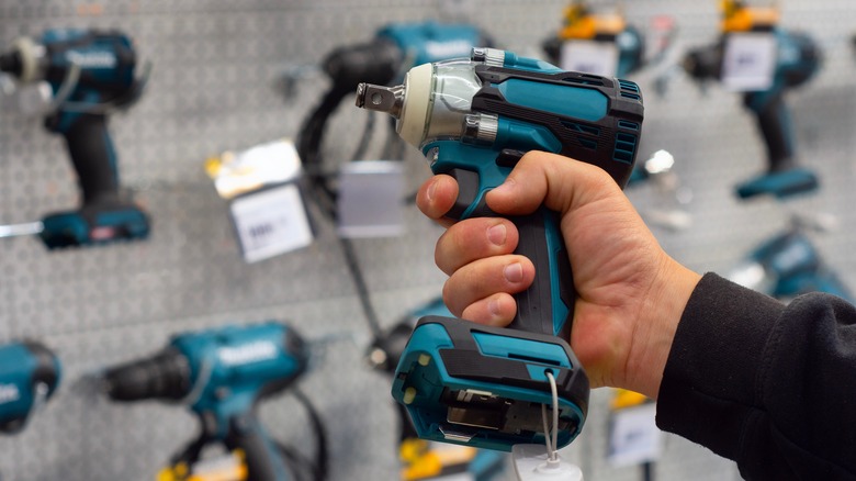A man choosing power tools in a store