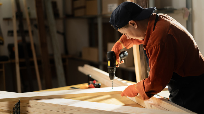 Person using a cordless drill for a woodworking project