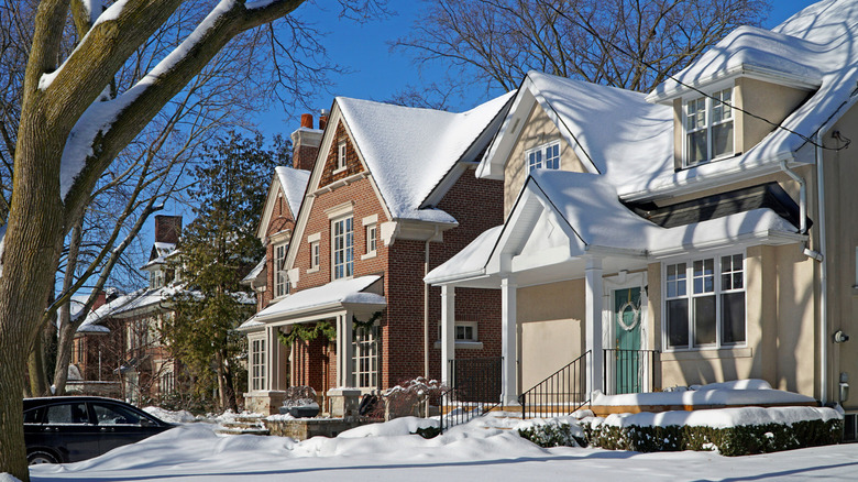 A row of snow-covered houses on a sunny day