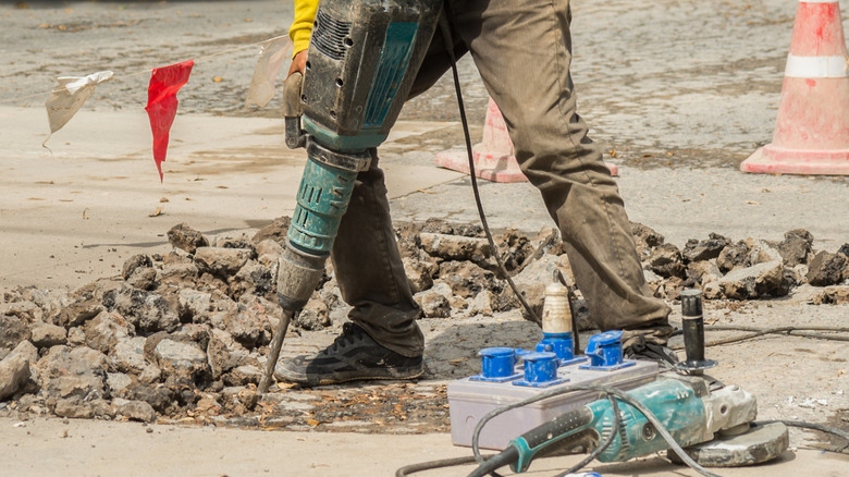 Person removing an asphalt driveway