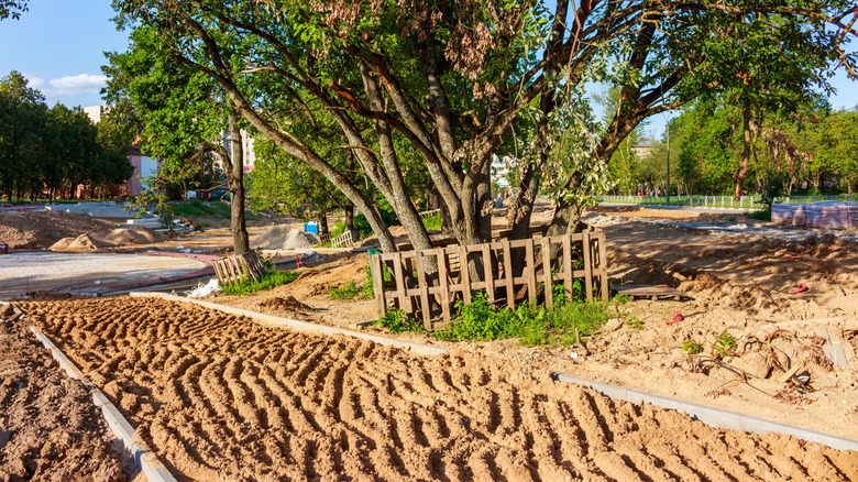 A wide walkway under construction in the front yard of an extensive residential property.