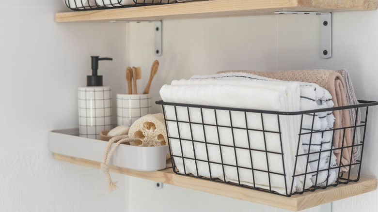 Bathroom shelf with bins of supplies and towels