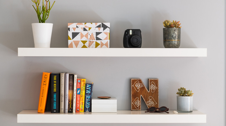 close up of white floating shelves with minimal decor