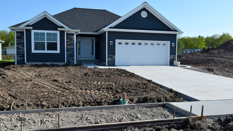 A newly constructed home with what looks like a white cement driveway