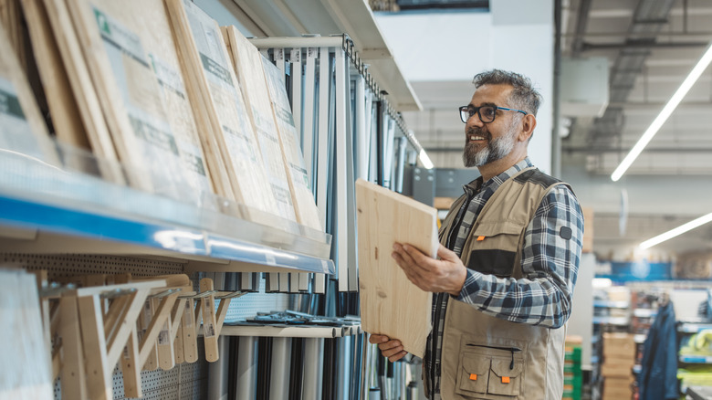 Man shopping for boring shelving parts at home improvement store.