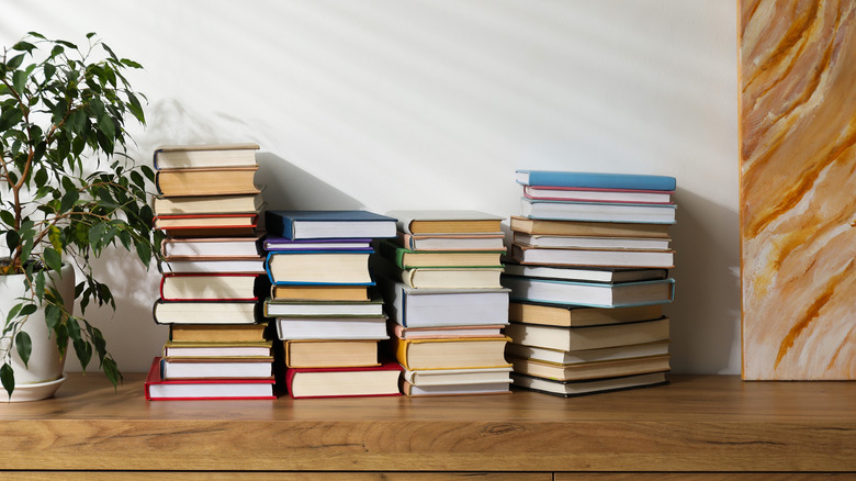 Piles of books on a dresser.